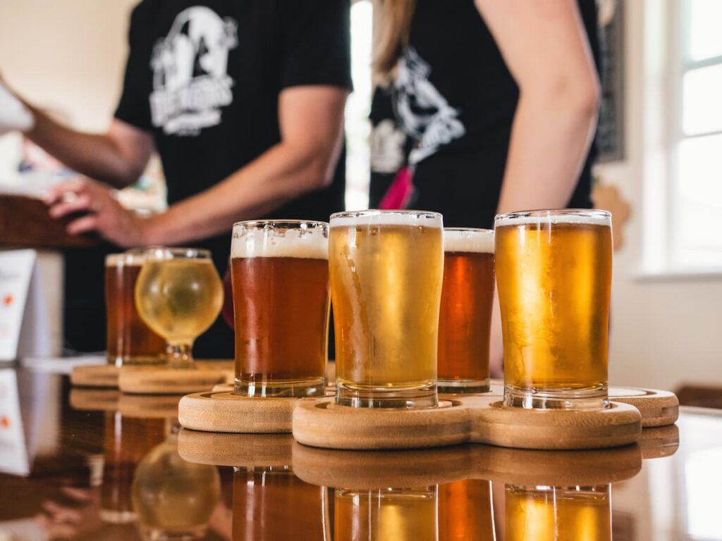 Vários copos de cerveja apoiados em uma mesa de madeira 