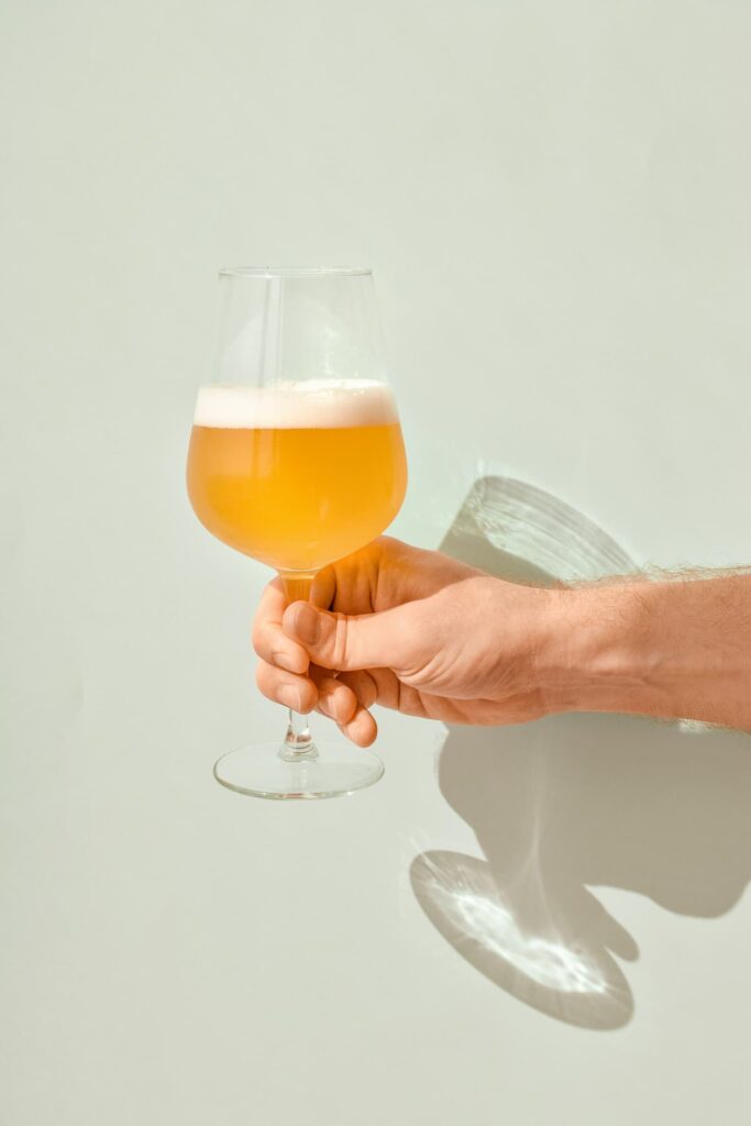 Uma pessoa segurando uma taça de cerveja 