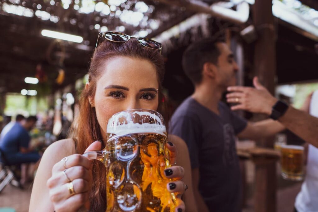 Uma mulher tomando uma caneca grande de cerveja 