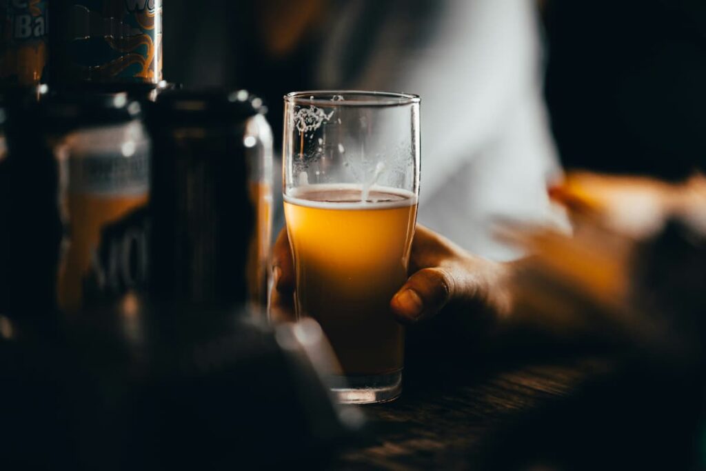 Uma pessoa segurando um copo de cerveja 