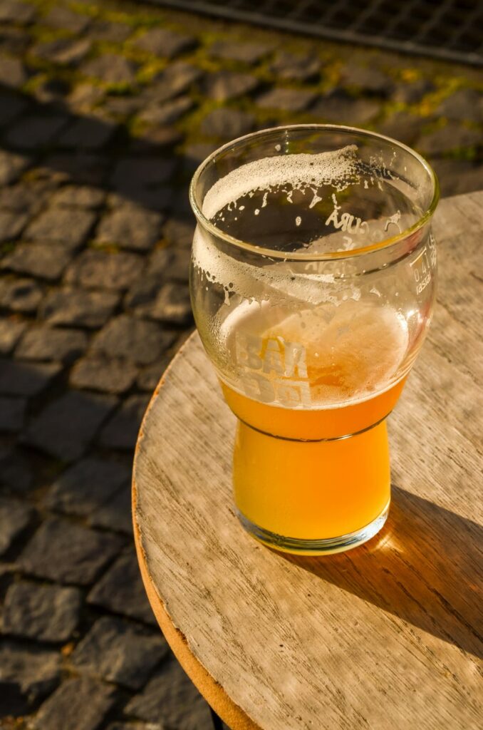 Um copo de cerveja apoiado em uma mesa de madeira 