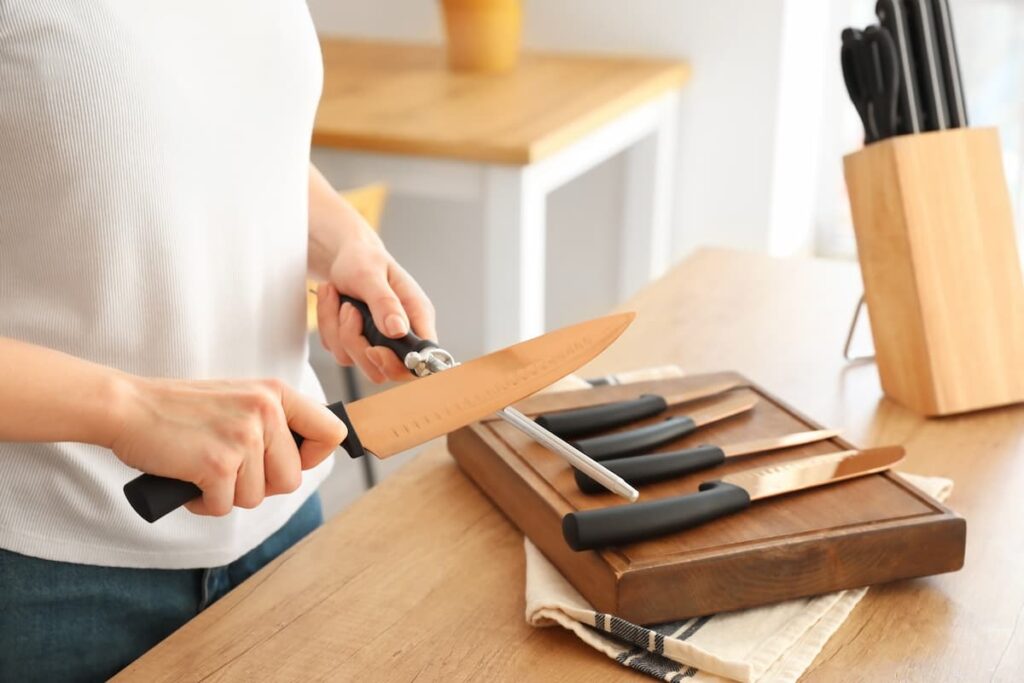 Uma pessoa amolando suas facas em sua cozinha