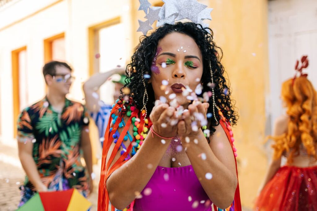 Uma mulher assoprando confete na câmera da foto
